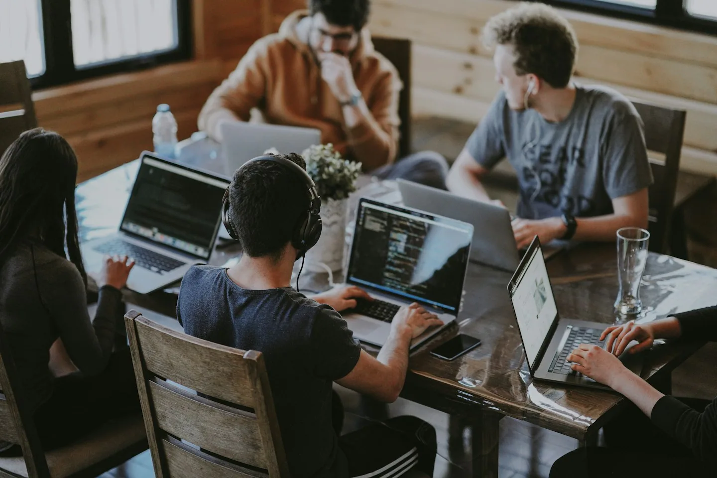 Menschen arbeiten gemeinsam mit Laptops an einem Tisch