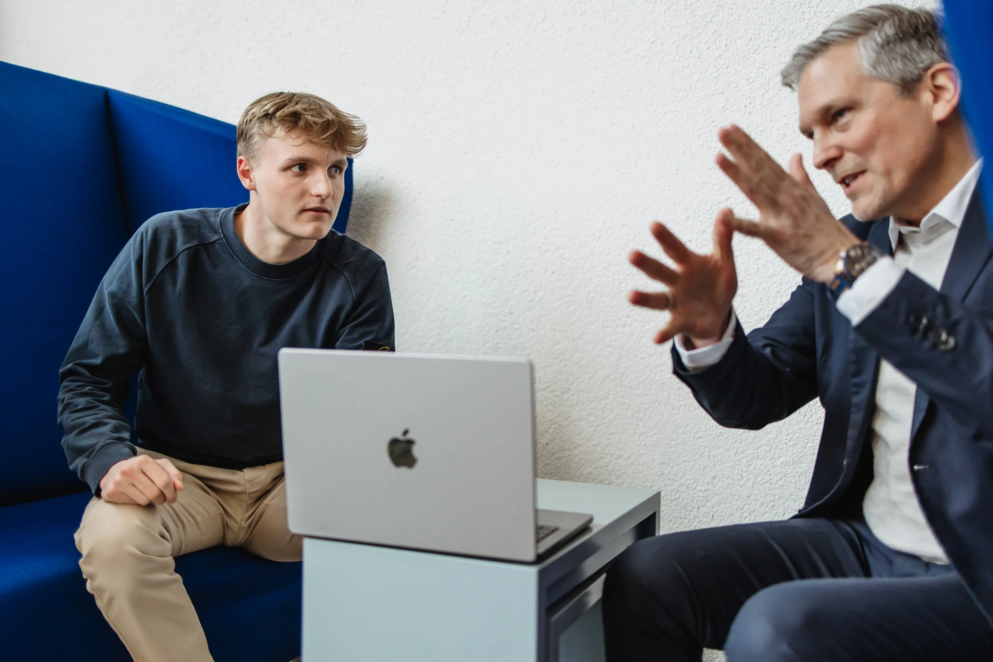 Erfahrener Ansprechpartner erklärt einem jungen Menschen ein Projekt