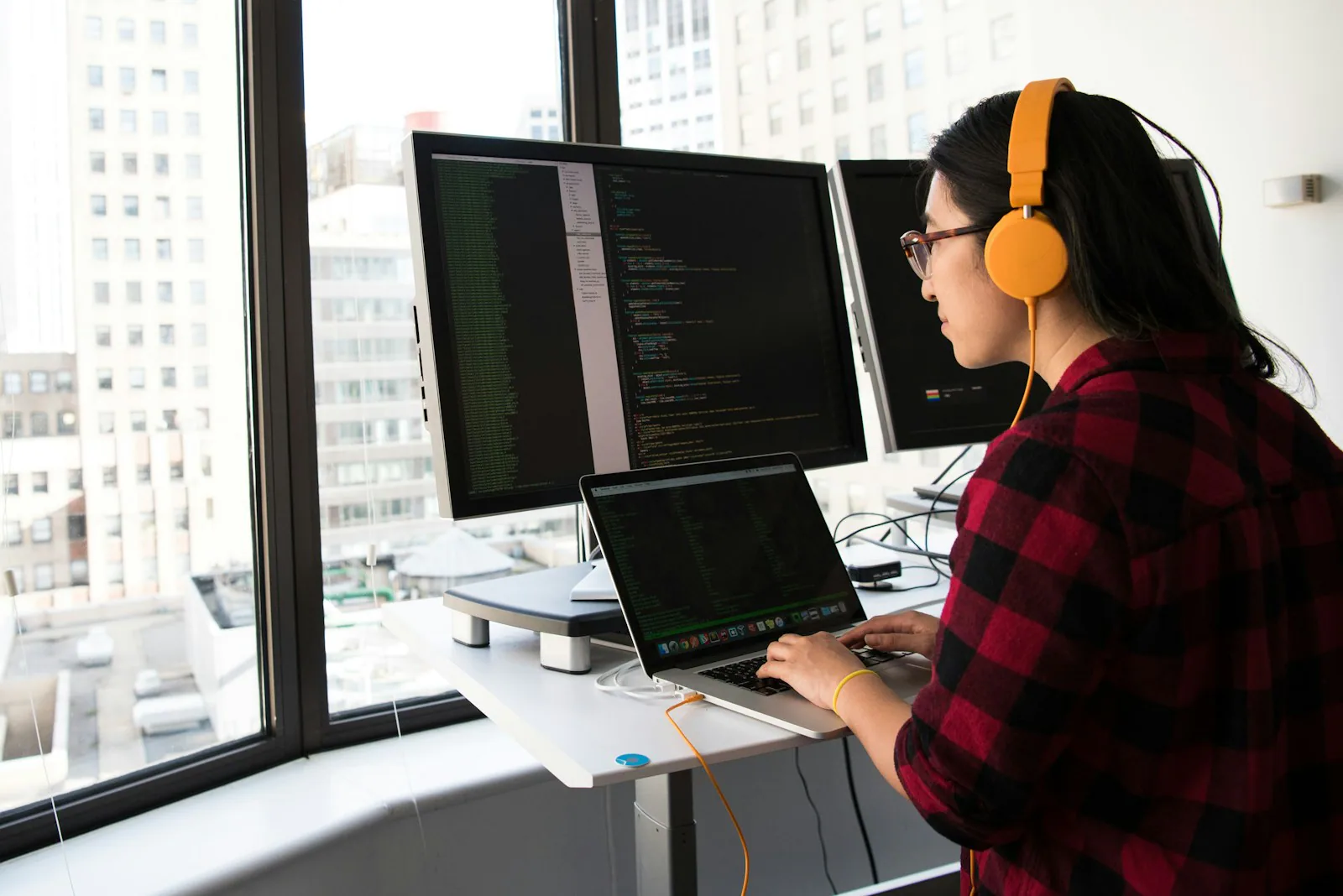 Eine Frau arbeitet an einem großen Bildschirm mit Programmcode.