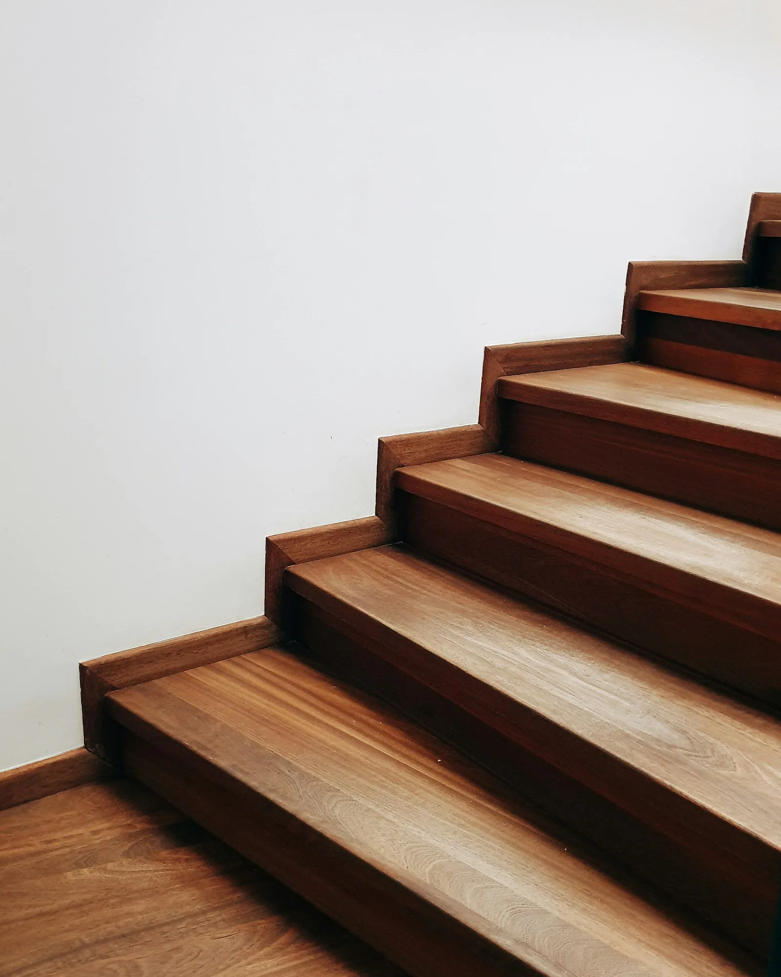 Eine Holztreppe führt um eine Ecke nach oben.