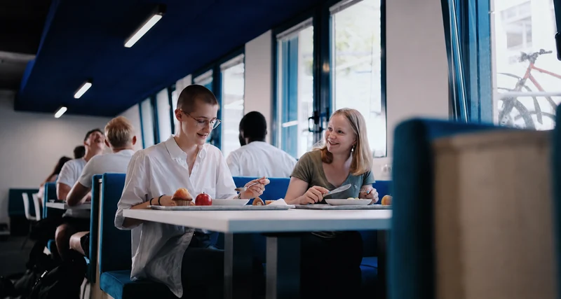 Studierende verbringen gemeinsam ihre Pause im Bistro der Hochschule.
