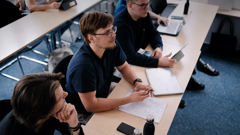 Studierende hören im Seminar zu und machen sich Notizen.