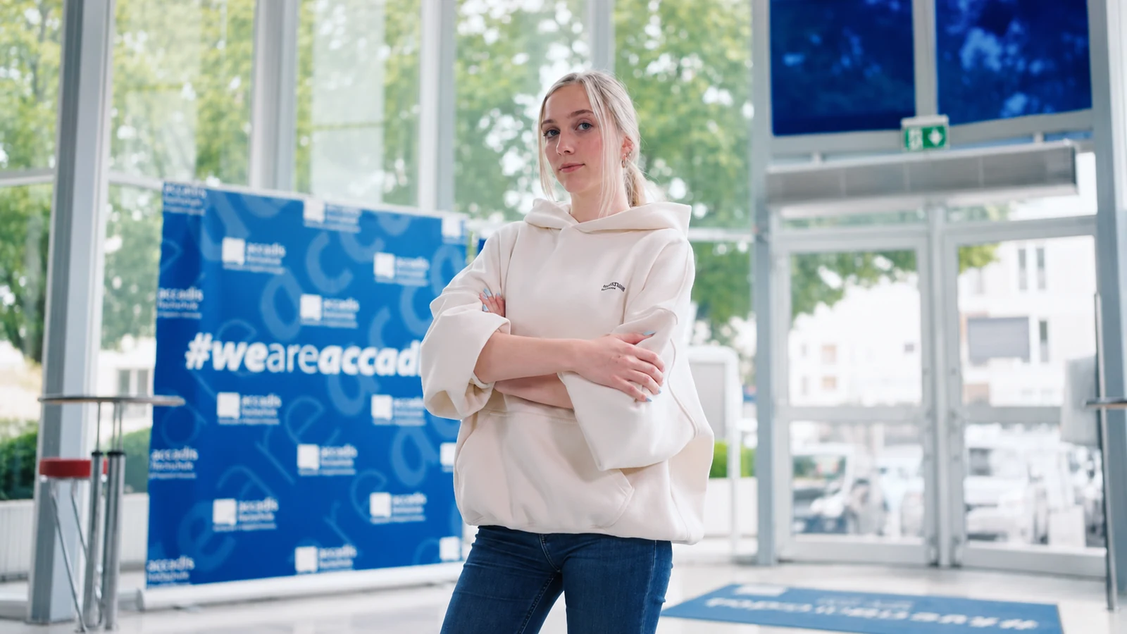 AI-Management-Studentin im hellen Foyer der accadis Hochschule