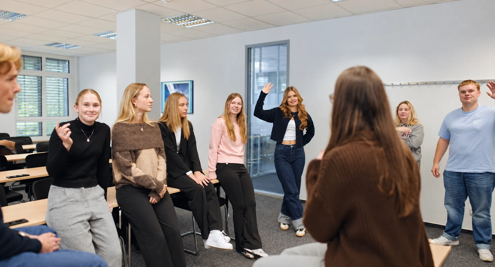 Junge Studierende lernen sich bei einer Gruppenübung im Seminarraum kennen