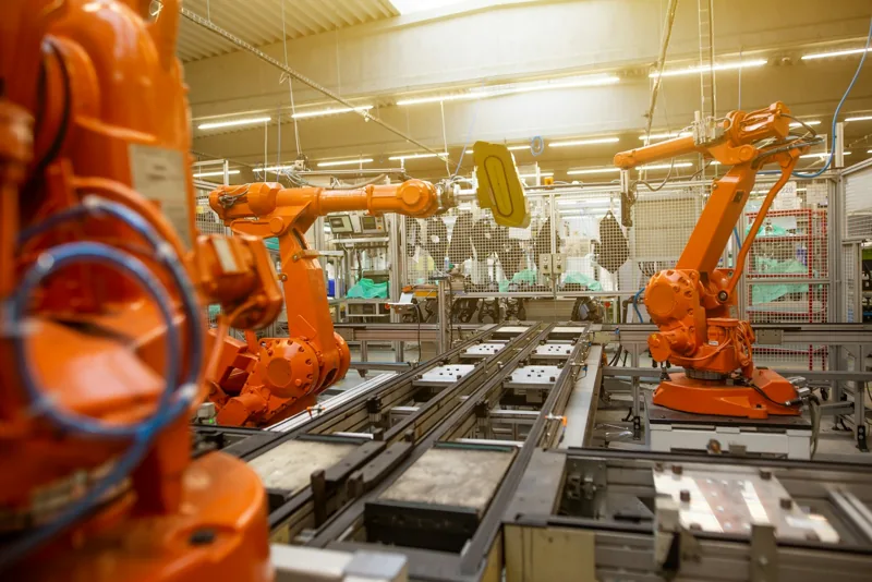Orange Industrieroboter an einer automatisierten Fertigungslinie.